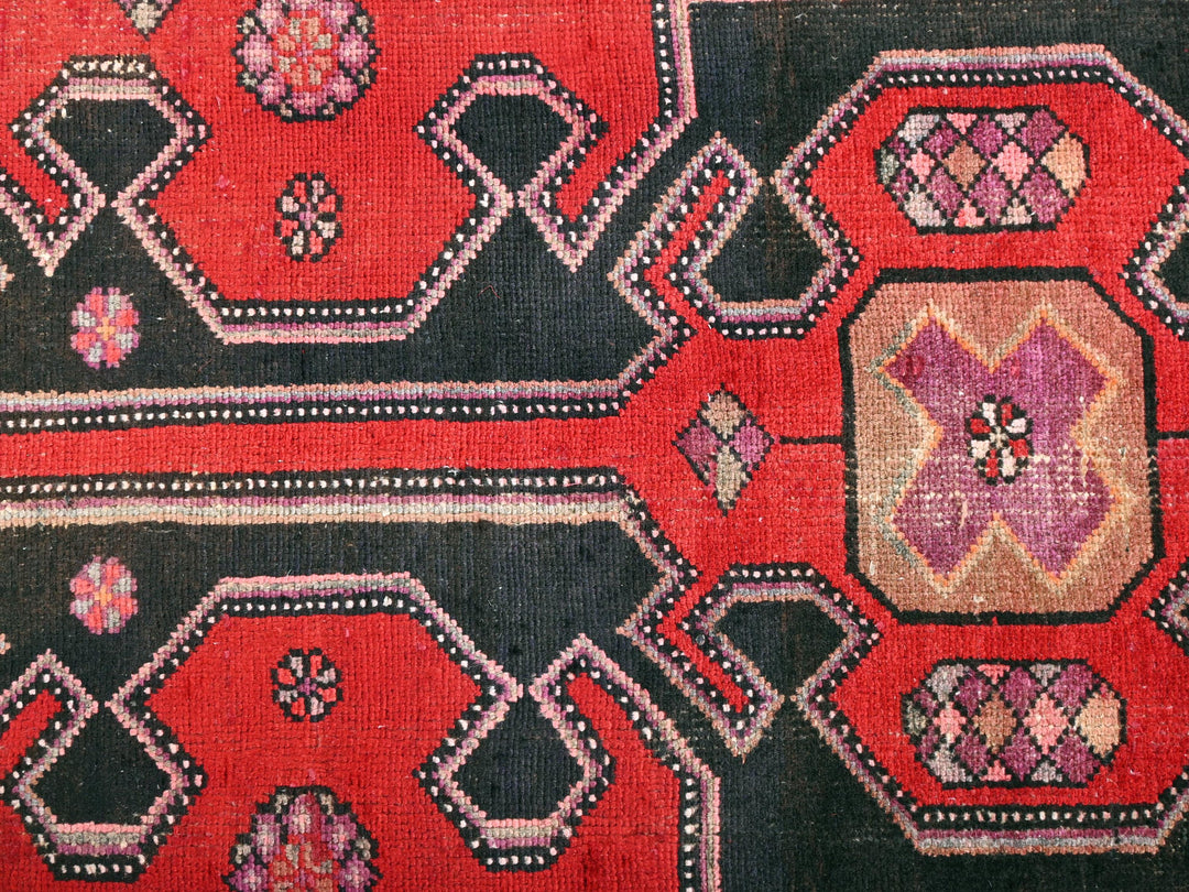 a close up of a red and black rug