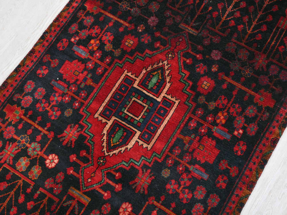 a red and black oriental rug on a white floor