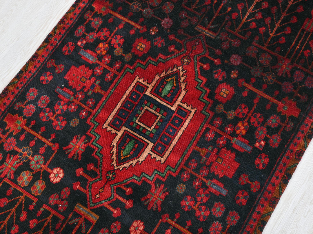 a red and black oriental rug on a white floor