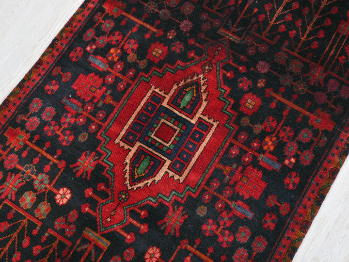 a red and black oriental rug on a white floor