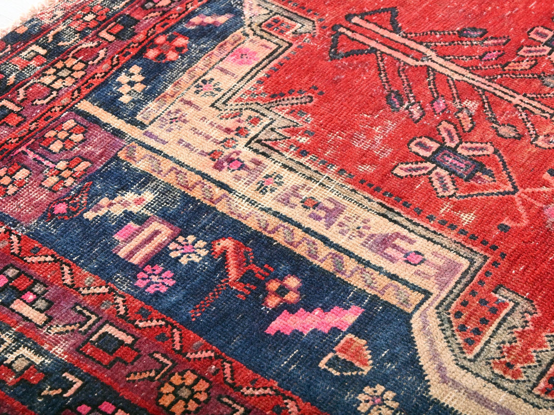 a red oriental rug with a blue border