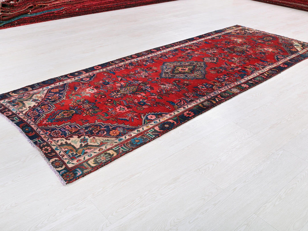 a red rug is laying on a white floor