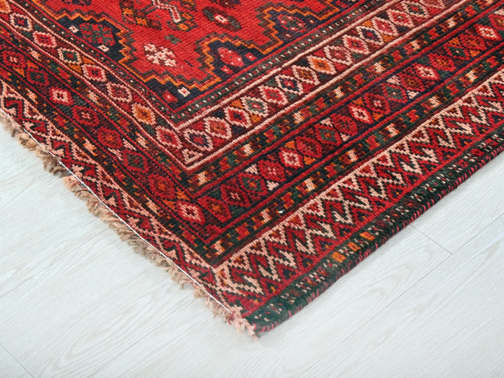 a close up of a red rug on a white floor
