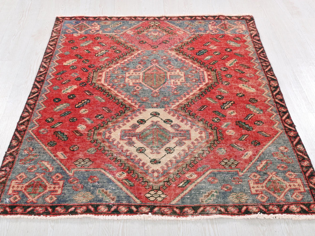 a red and blue rug on a white floor