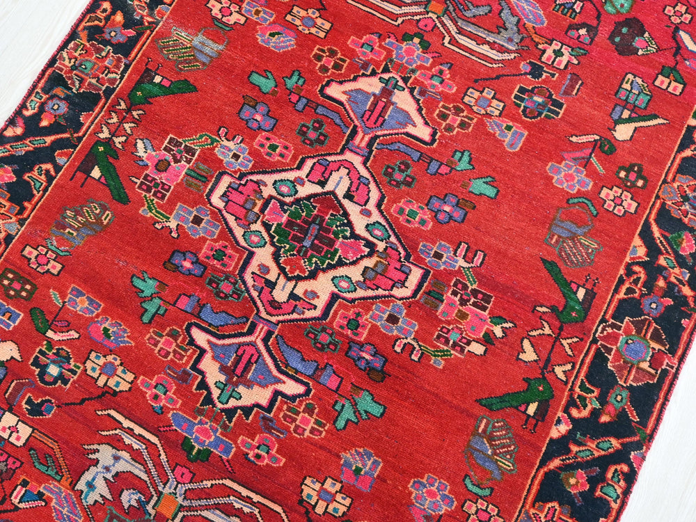 a red oriental rug on a wooden floor
