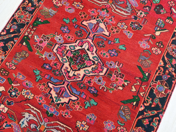 a red oriental rug on a wooden floor