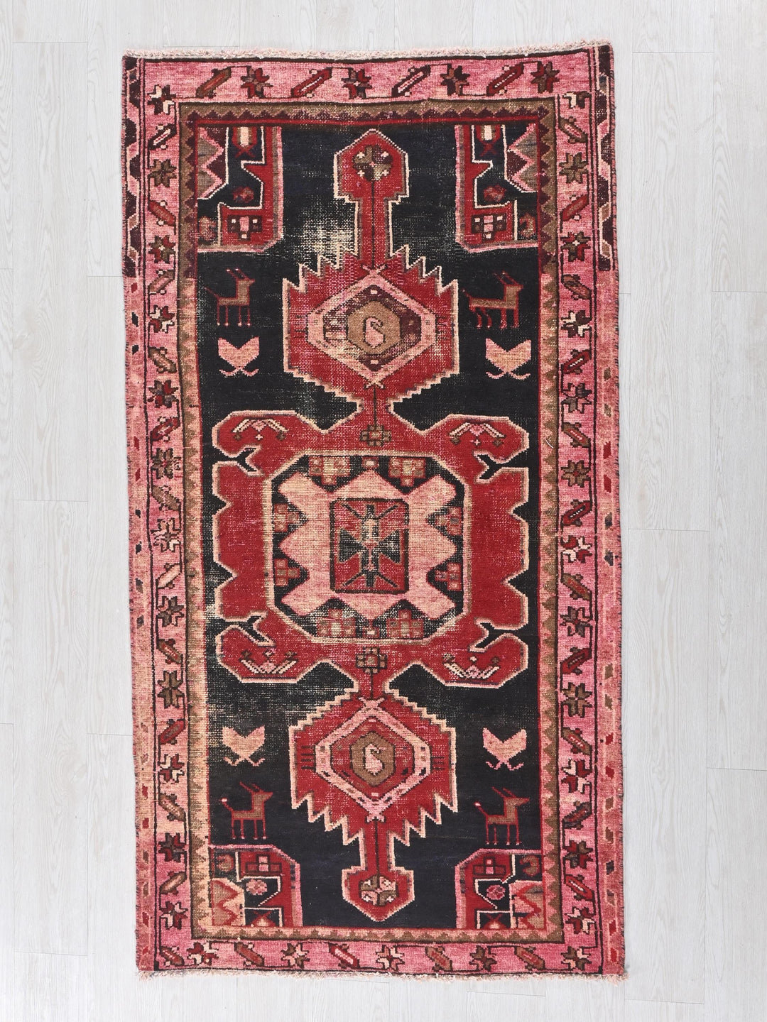 a red and black rug hanging on a wall