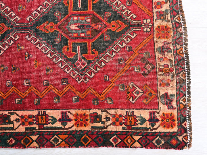 a red rug with a design on the middle of it
