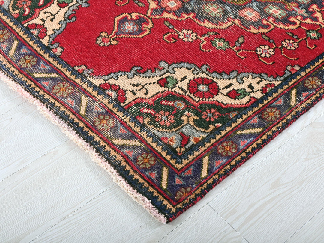 a red oriental rug on a white wooden floor