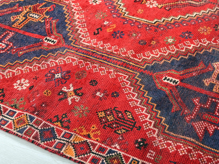 a red rug with a blue and red design on it