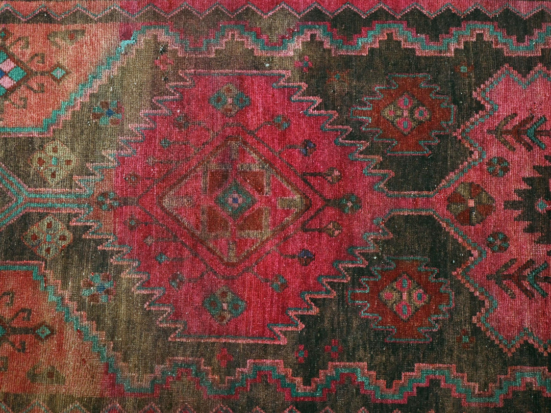 a red, green, blue, and brown rug with a diamond pattern