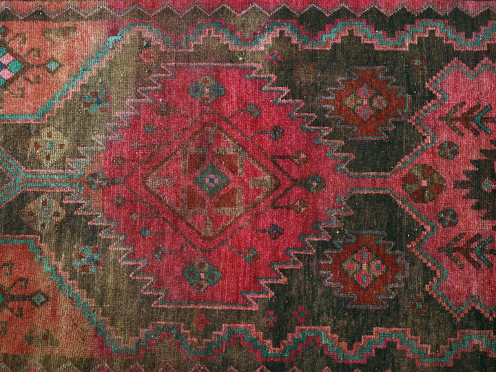 a red, green, blue, and brown rug with a diamond pattern