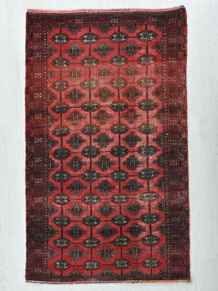 a red and black rug on a white floor