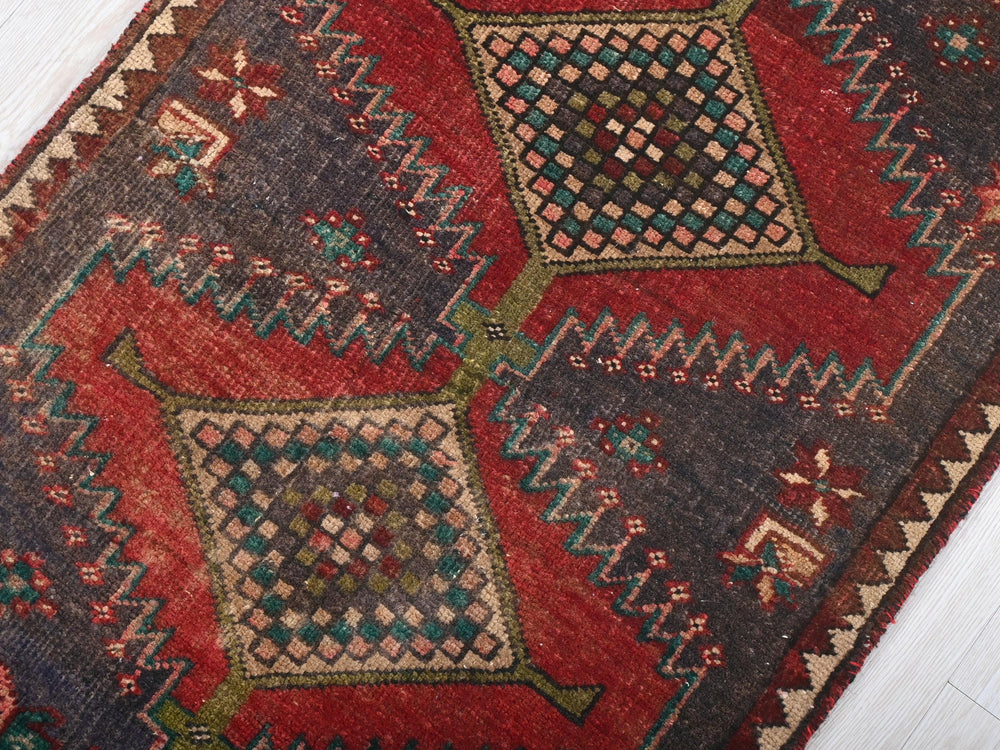 a red and blue rug on a white floor