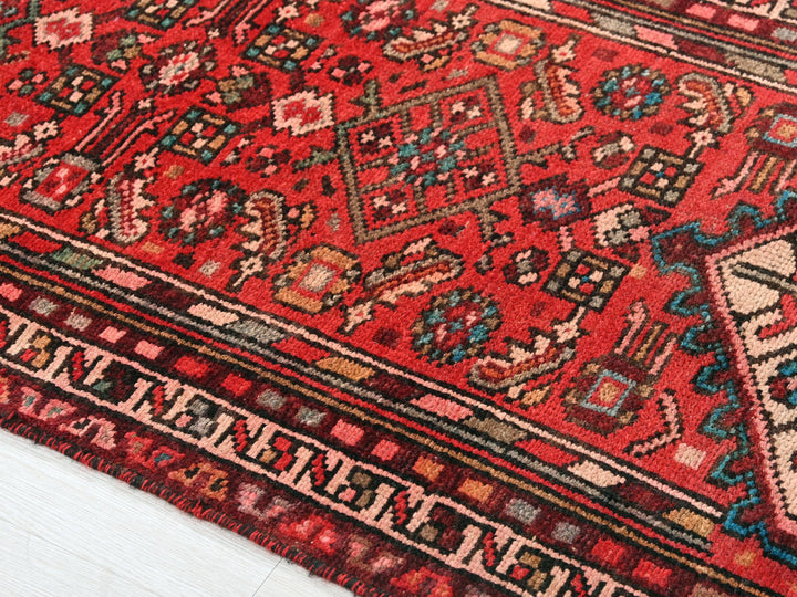 a red oriental rug on a white floor