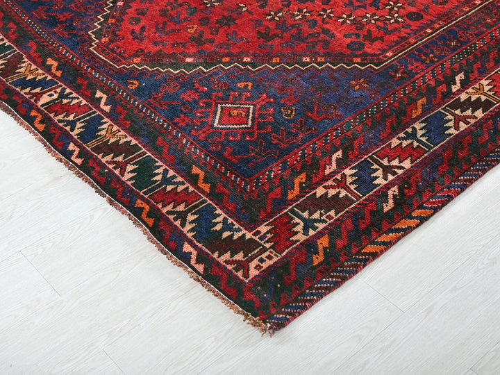 a red and blue oriental rug on a white floor