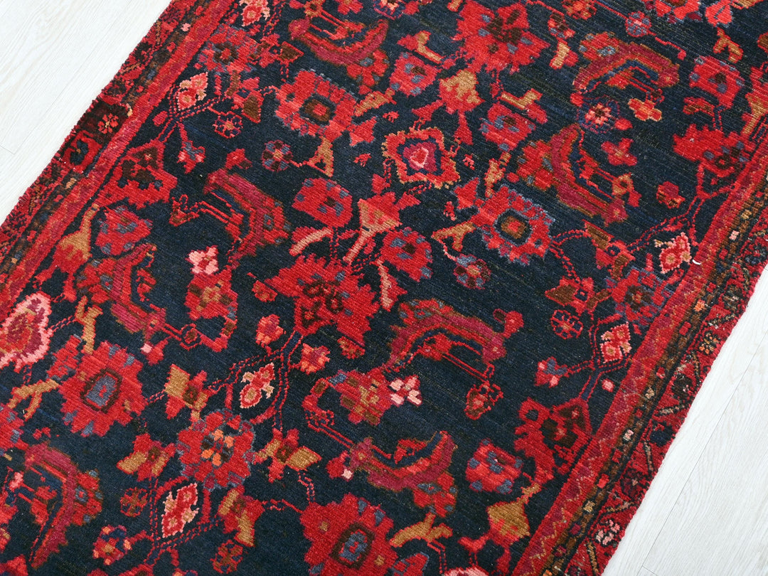 a red and black oriental rug on a white floor
