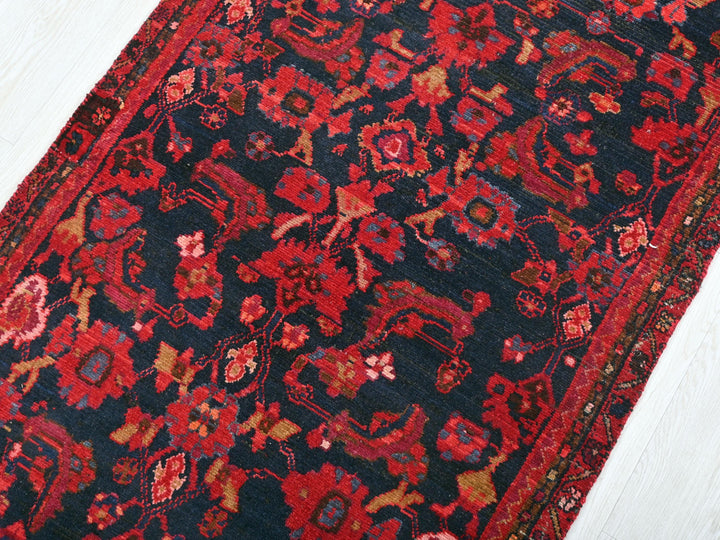 a red and black oriental rug on a white floor
