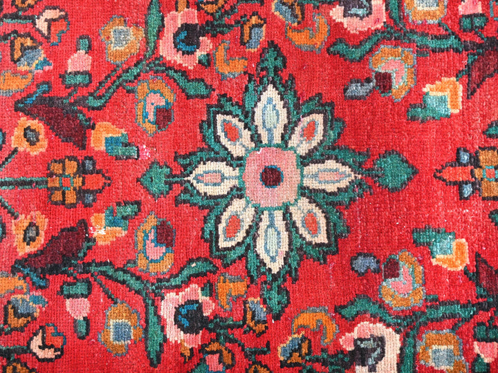 a close up of a red rug with a flower design