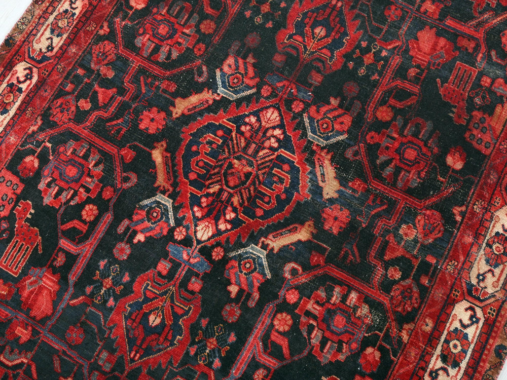 a red and black oriental rug on a white surface
