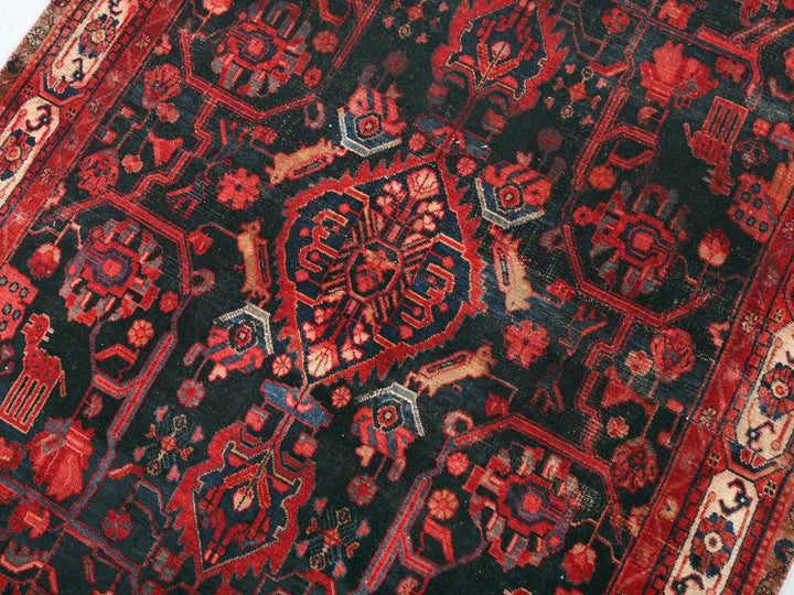 a red and black oriental rug on a white surface