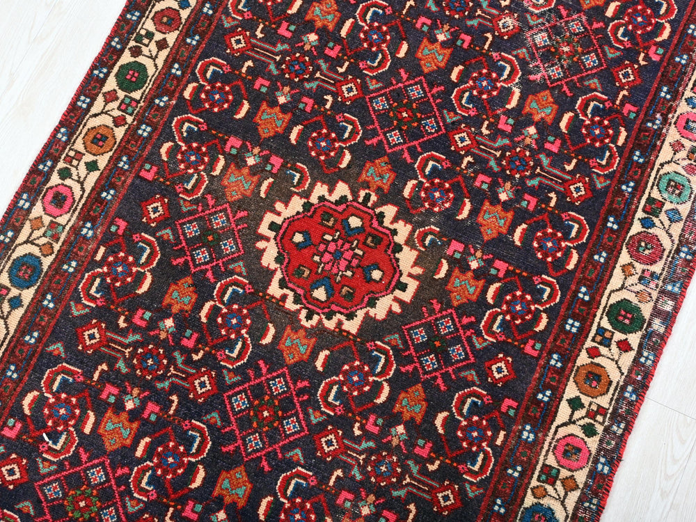 a red and blue oriental rug on a white floor