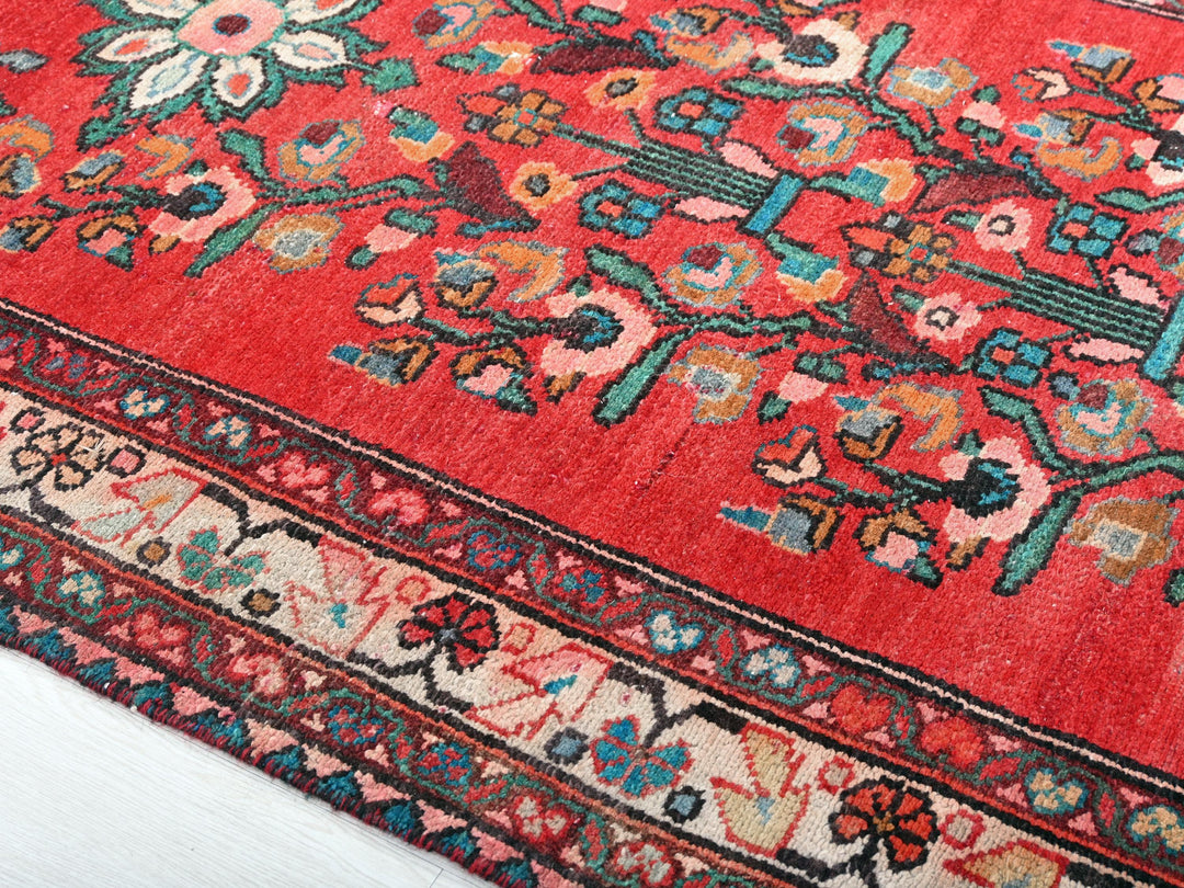 a red rug with a floral design on it