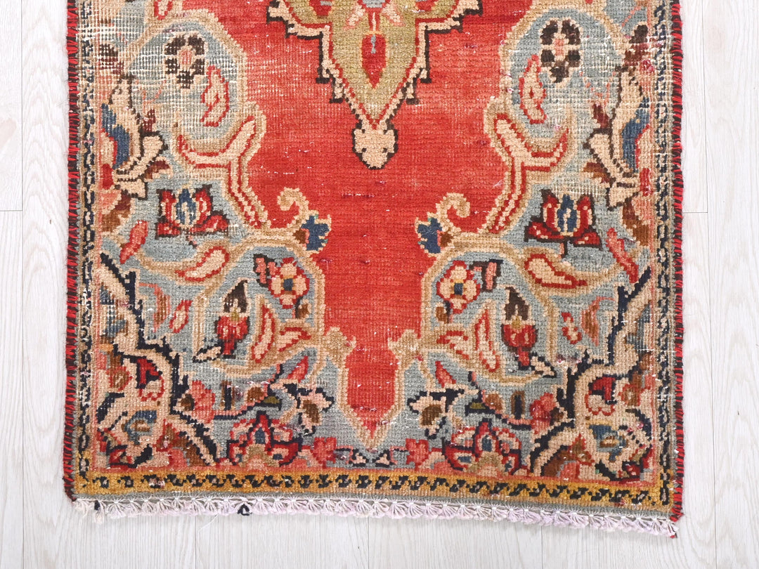 a red and blue rug on a white floor