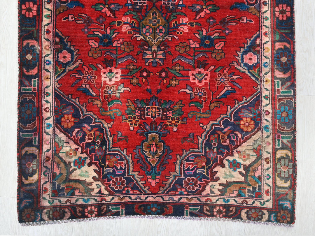 a red rug with a floral design on it