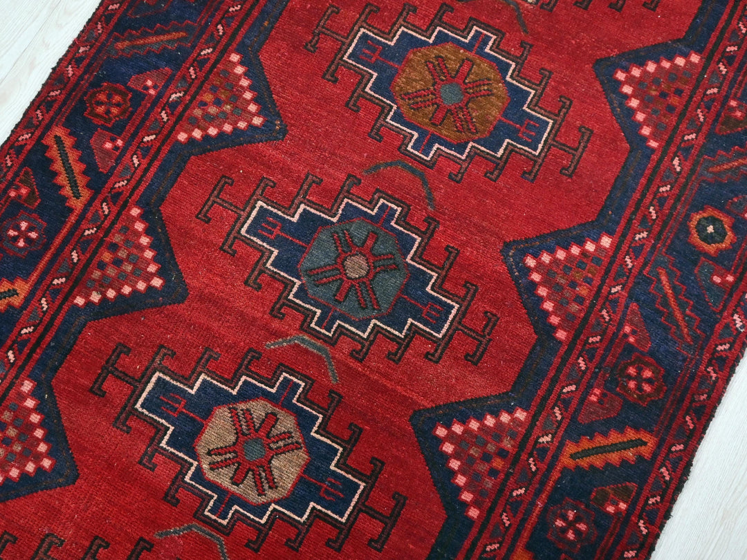 a red rug with blue and red designs on it
