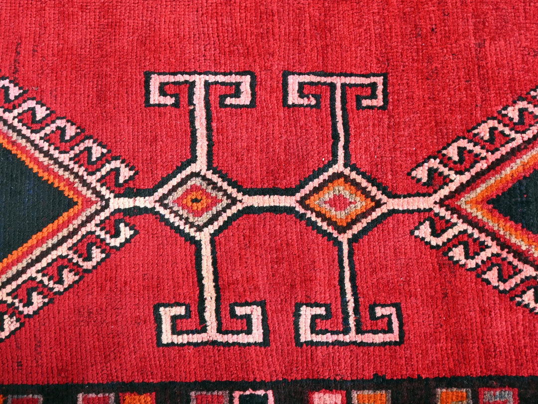 a close up of a red rug with a design on it