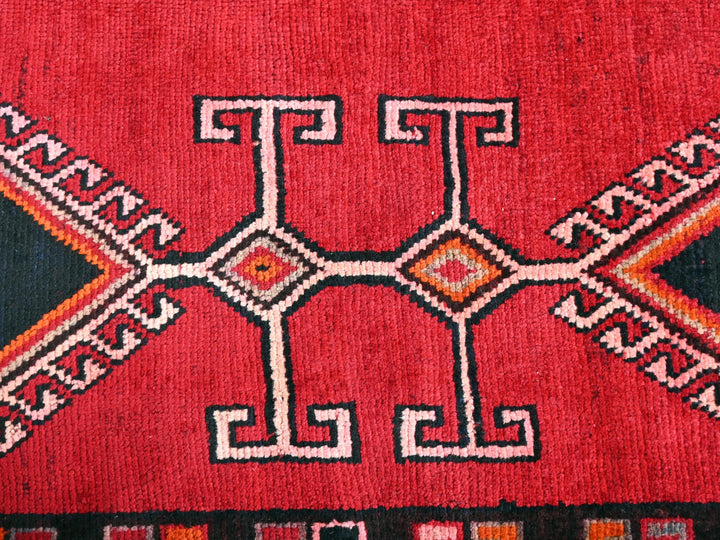 a close up of a red rug with a design on it