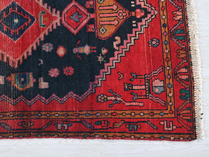 a red and black oriental rug on a white surface