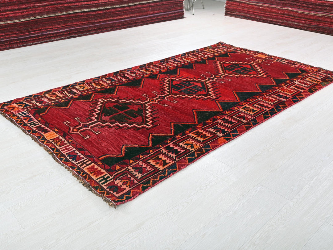 a red area rug on a white floor