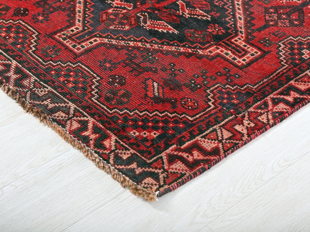 a red and black oriental rug on a white floor