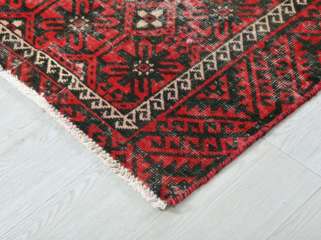 a red and black rug on a white floor