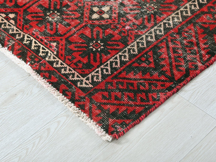 a red and black rug on a white floor