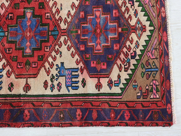 a red and blue rug on a white surface