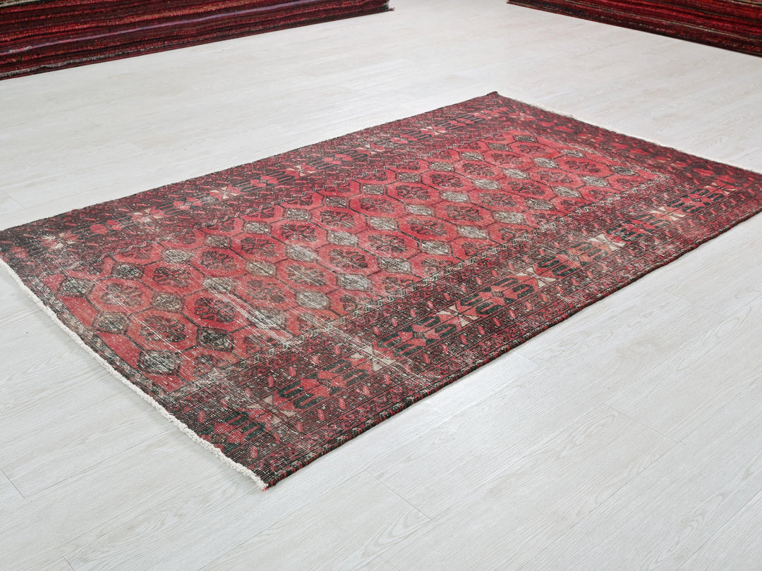a red and black rug on a white floor