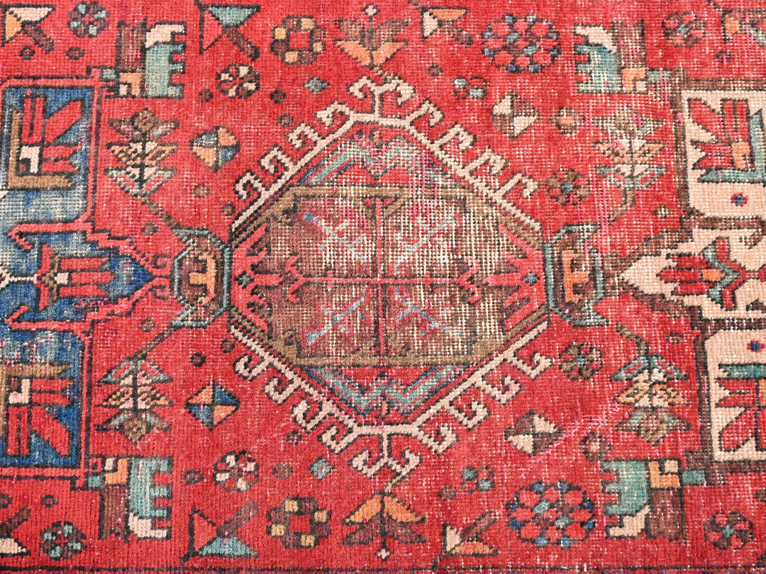 a red rug with a design on the middle of it