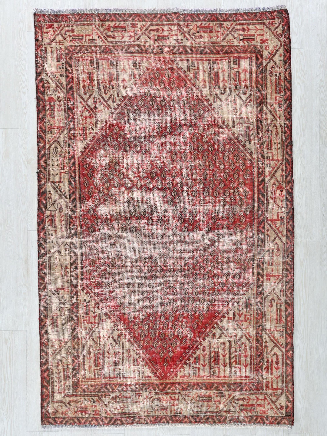 a red and beige rug with a diamond design