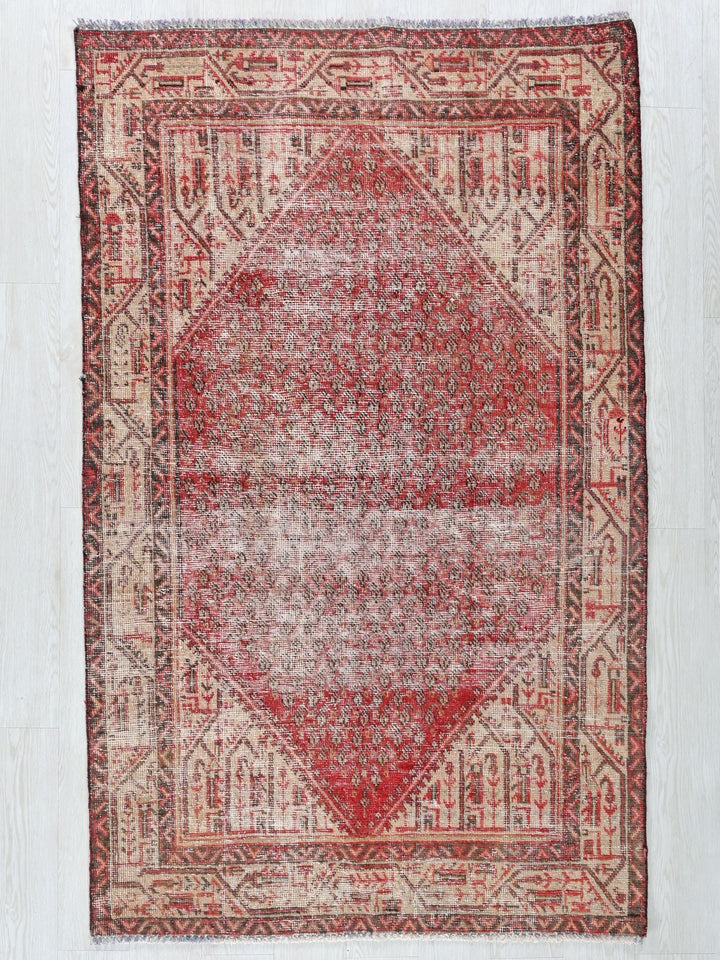 a red and beige rug with a diamond design