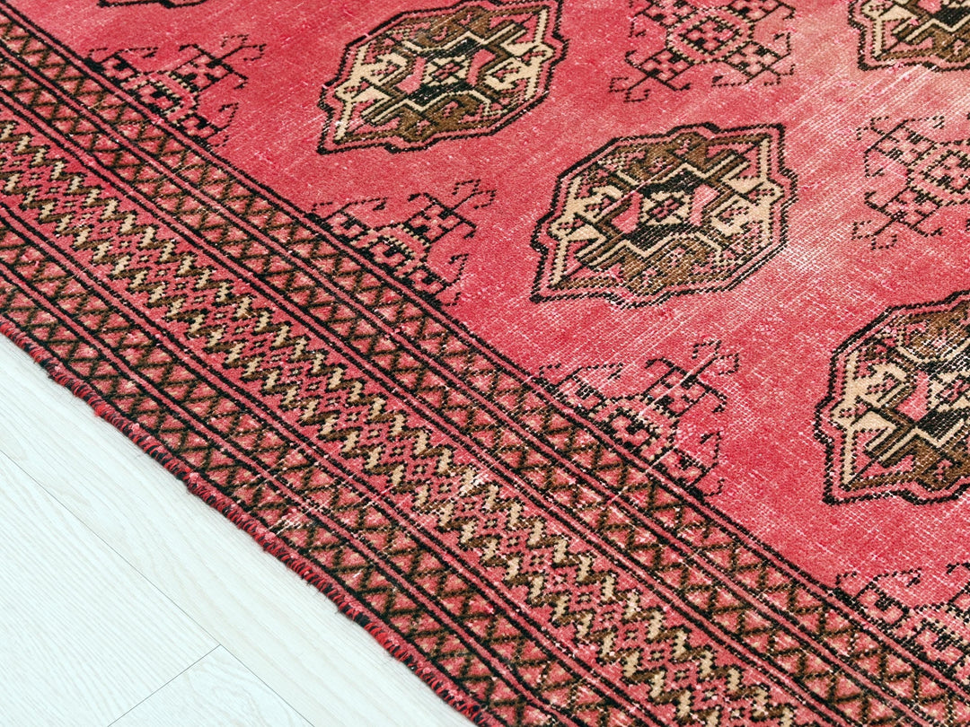 a close up of a red rug on a white floor