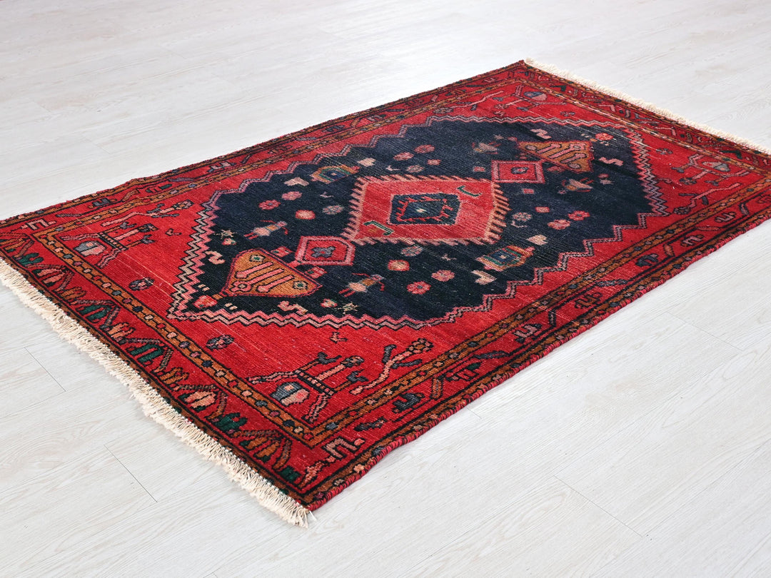 a red and black rug on a white floor