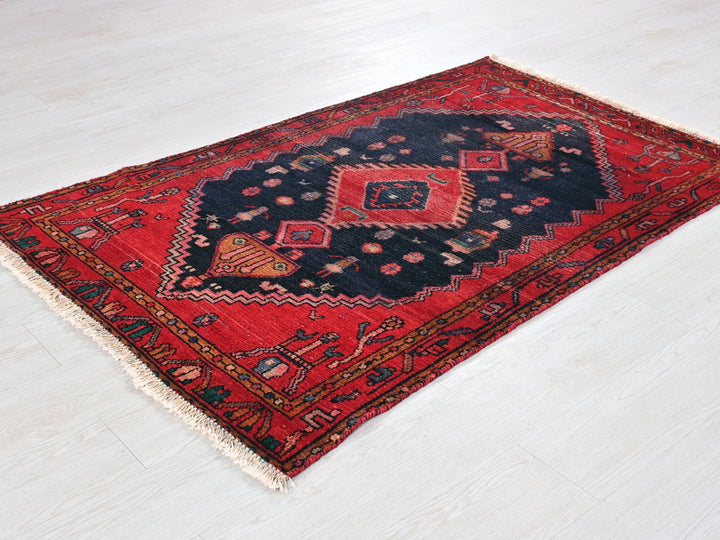 a red and black rug on a white floor