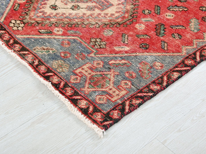 a red and blue rug on a white floor