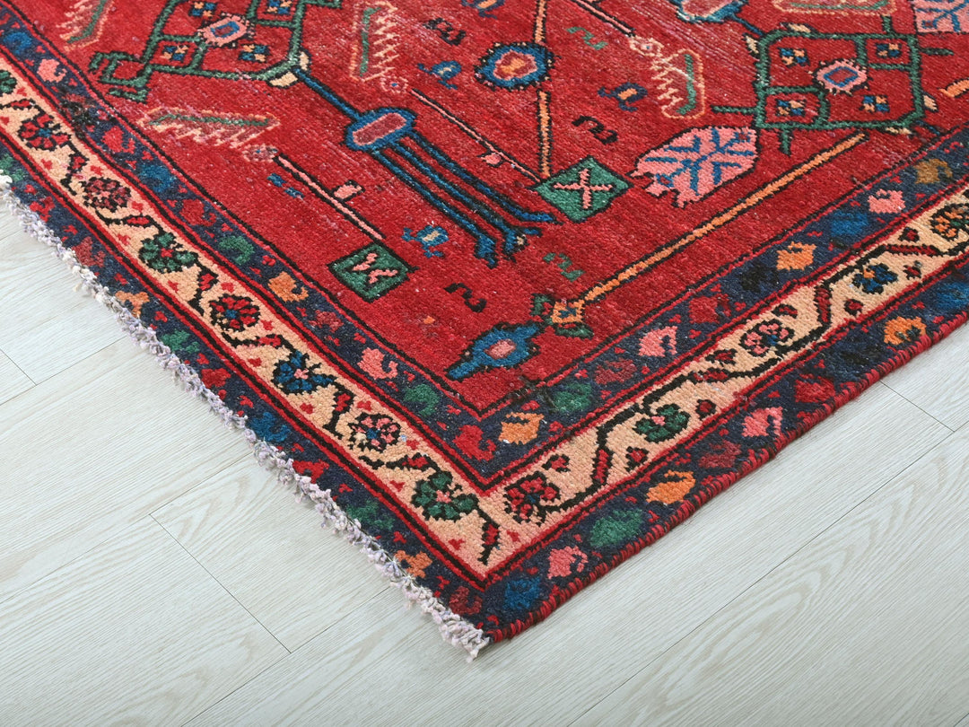 a red oriental rug on a white wooden floor