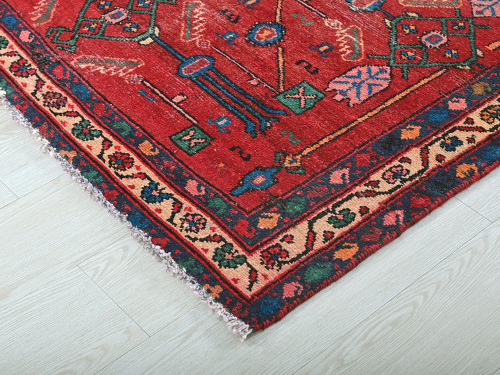 a red oriental rug on a white wooden floor