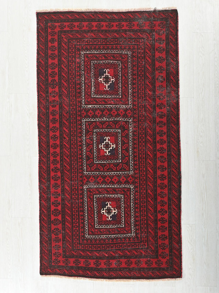 a red and black rug on a white floor