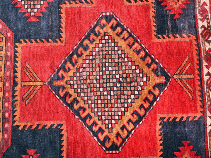 a red and blue rug with a diamond design